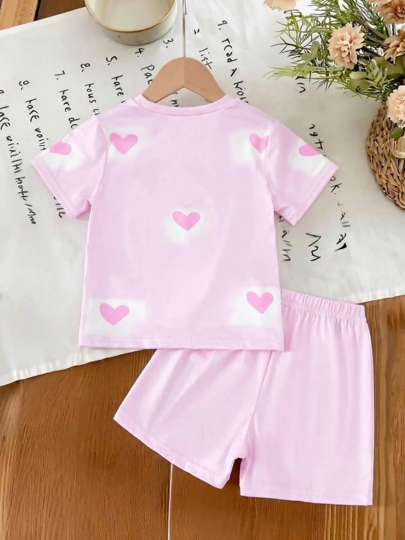Girls' sweet pink short-sleeve top and shorts set featuring an all-over heart and cartoon idol print; a cute, casual, and versat